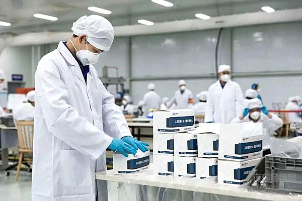 上汽通用五菱的无尘车间，工人正在批量包装生产的口罩